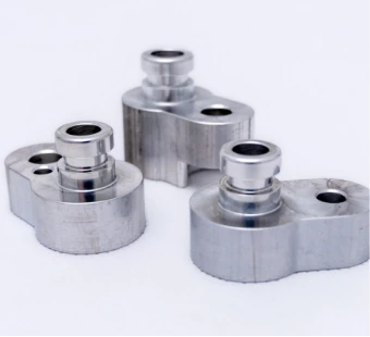 Three milled aluminium parts with sleeves